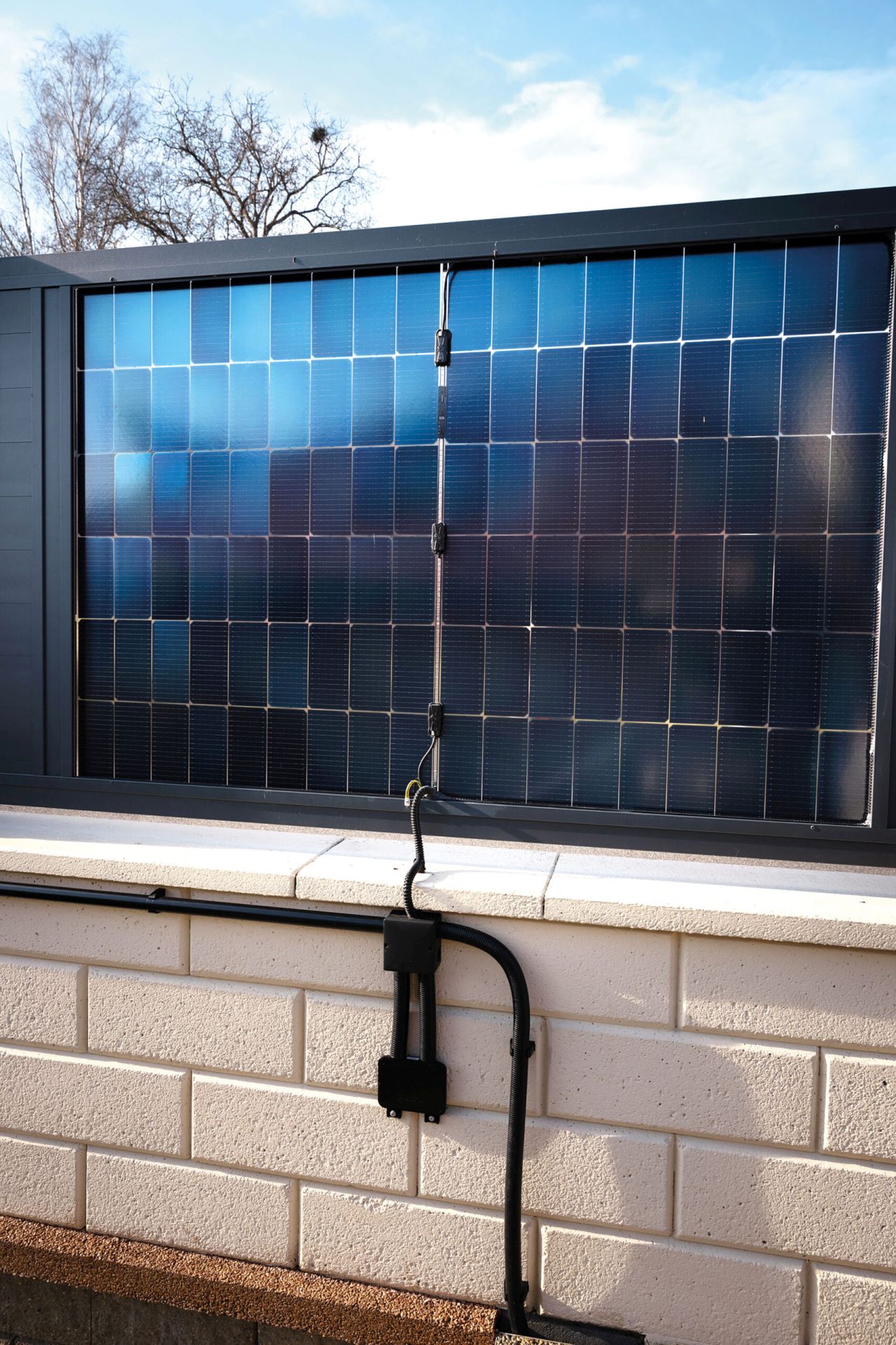 Ze strany zahrady na panely dopadají sluneční paprsky z východu. Když se slunce po obědě přehoupne na západ, vyrábí elektřinu část plotu obrácená do ulice. Foto: Marek Knittl, Reportér